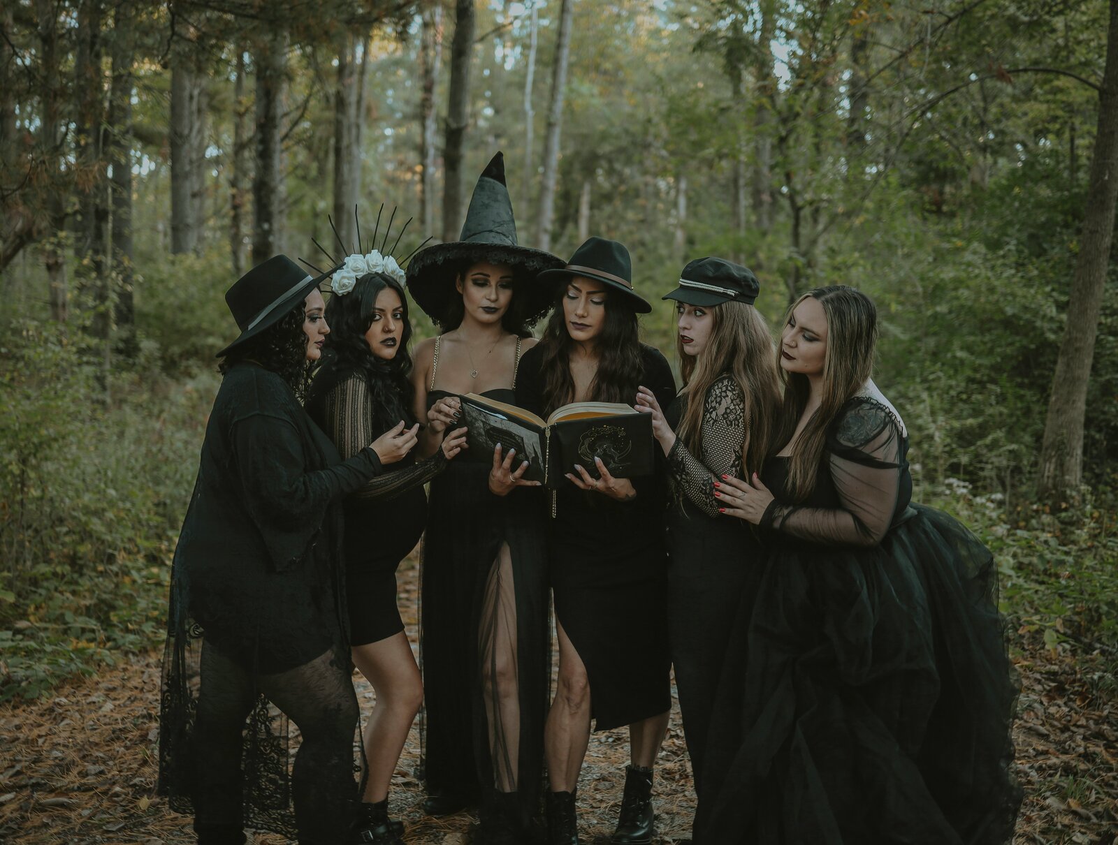 A circle of women in black gathered in the forest